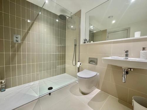 a bathroom with a toilet and a shower and a sink at 47 The Rest in Porthcawl