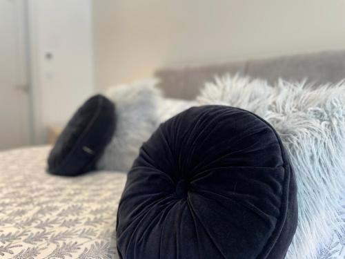 a black pillow sitting on top of a bed at 47 The Rest in Porthcawl