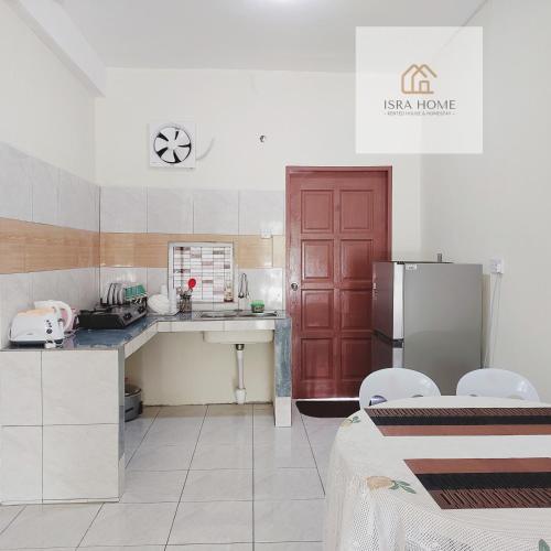 uma cozinha com uma porta vermelha e um frigorífico em ISRA HOME em Ranau