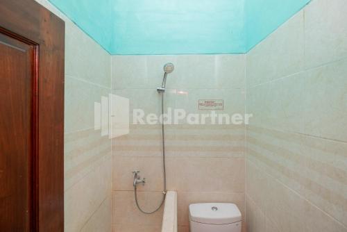 a bathroom with a shower with a toilet at Hotel Wisata Ziarah Sunan Bonang Syariah Mitra RedDoorz in Tuban