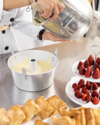a person is preparing strawberries on plates on a counter at Hotel Majorca in Gabicce Mare