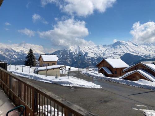 a view of a snow covered mountain with buildings at Appartement dans un chalet, résidence avec piscine in La Toussuire