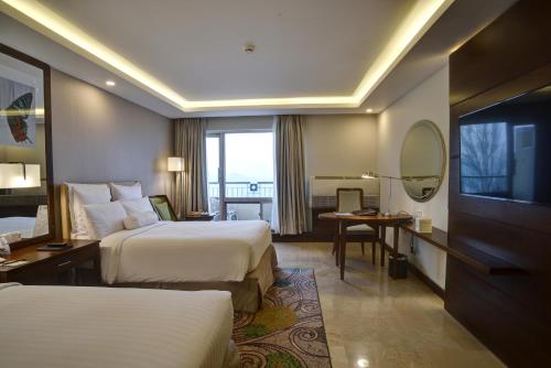 a hotel room with two beds and a television at Pearl Continental Hotel, Bhurban in Bhurban