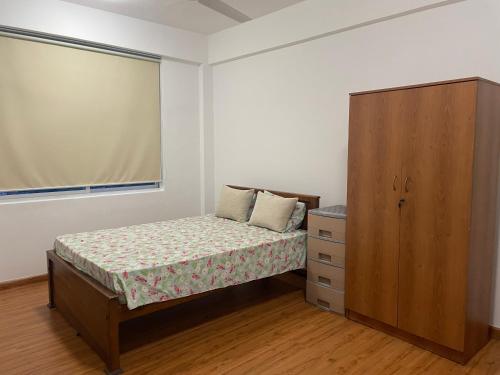 マウントラビニアにあるRush Resident Mount Laviniaの小さなベッドルーム(ベッド1台、キャビネット付)