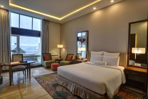 a hotel room with a bed and a large window at Pearl Continental Hotel, Bhurban in Bhurban