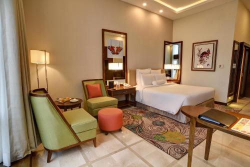 a hotel room with a bed and a desk and chair at Pearl Continental Hotel, Bhurban in Bhurban