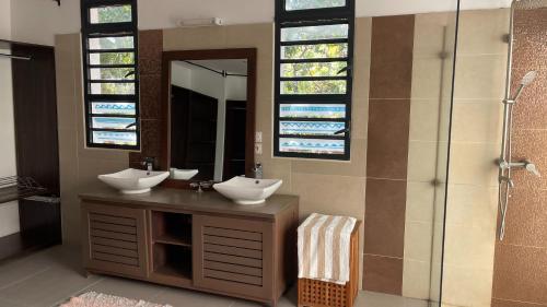 een badkamer met 2 wastafels en een douche bij La Médina Majunga in Mahajanga