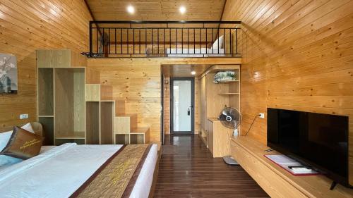 a bedroom with a bed and a television in a room at LePont Cat Ba Bungalow in Cat Ba