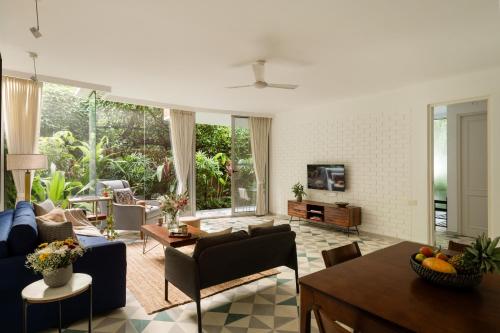 a living room with a couch and a table at El Sereno 2 BHK Stylish Apartments In Vagator with Garden and Pool- 10 minutes drive to Vagator Beach in Chapora