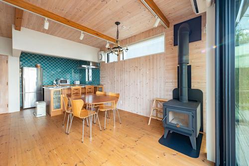 葉山町的住宿－南葉山 - Seaside Cabin in Minami-hayama，厨房以及带燃木炉的用餐室。
