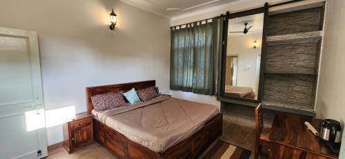 1 dormitorio con cama y espejo grande en Luxe Villa by Hridhyam Group, en Dehradun