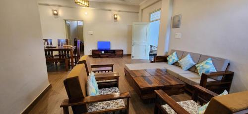 sala de estar con sofá y mesa en Luxe Villa by Hridhyam Group, en Dehradun