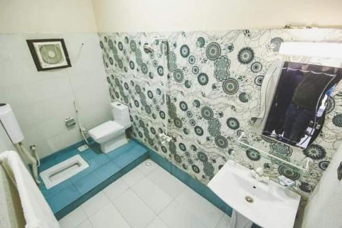 a bathroom with a sink and a toilet in it at The R Hotels in Karachi