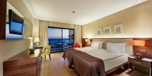 a hotel room with a bed and a balcony at TUl BLUE Side Adult Only 16 Plus - Ultra All Inclusive in Side