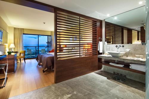 a bathroom with a sink and a bedroom with a bed at TUl BLUE Side Adult Only 16 Plus - Ultra All Inclusive in Side