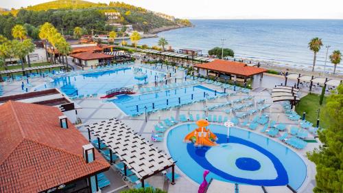 an overhead view of a swimming pool with chairs and the ocean at Kustur Club Holiday Village - All Inclusive in Kusadası