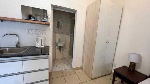 a small kitchen with a sink and a bathroom at Casablanca Guest House in Durban