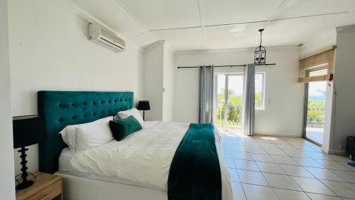a bedroom with a large bed with a blue headboard at Casablanca Guest House in Durban
