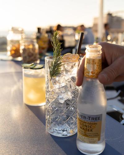 a person holding a bottle of water next to a drink at Hotel Majorca in Gabicce Mare