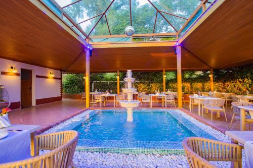 a swimming pool with a fountain in the middle of a restaurant at Kustur Club Holiday Village - All Inclusive in Kusadası