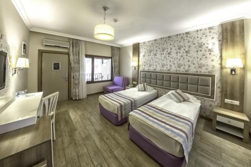 a hotel room with two beds and a sink at Kustur Club Holiday Village - All Inclusive in Kusadası