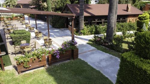 a garden with tables and chairs and purple flowers at Kustur Club Holiday Village - All Inclusive in Kusadası