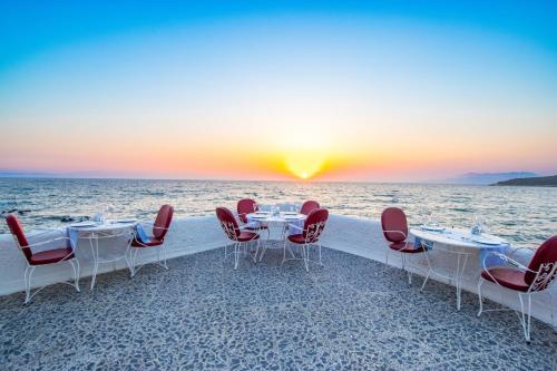 a table and chairs on the beach at sunset at Kustur Club Holiday Village - All Inclusive in Kusadası