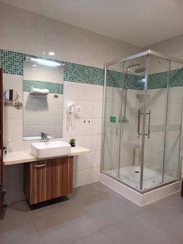 a bathroom with a sink and a shower at Changchun Clear Moon Apartment by South Lake Hotel in Changchun
