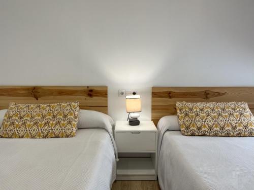 two beds sitting next to each other in a bedroom at Pensión Galicia in Badajoz