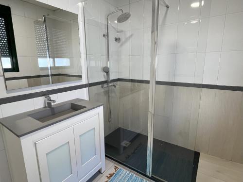 y baño con ducha y lavamanos. en Pensión Galicia, en Badajoz