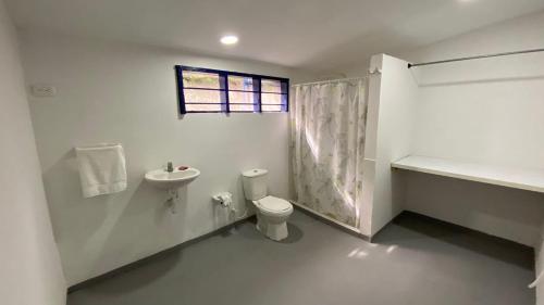 a bathroom with a sink and a toilet and a window at Punta Arena Beach Hostel in Playa Punta Arena
