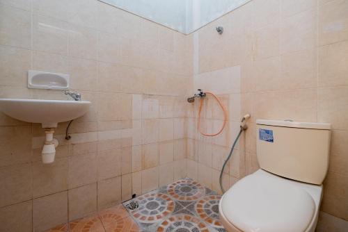 a bathroom with a toilet and a sink at RedDoorz Syariah at Jalan Sunan Giri Tuban in Tuban