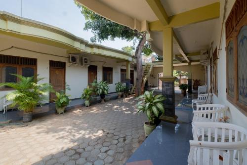 a courtyard of a house with white benches and plants at RedDoorz Syariah at Jalan Sunan Giri Tuban in Tuban