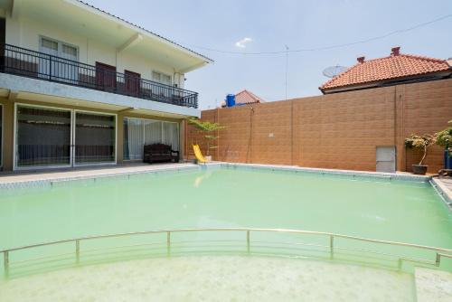 a large swimming pool with blue water in a building at RedDoorz Syariah at Jalan Sunan Giri Tuban in Tuban