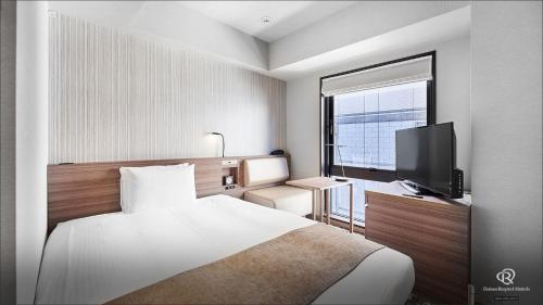 a hotel room with a bed and a television at Daiwa Roynet Hotel Shimbashi in Tokyo