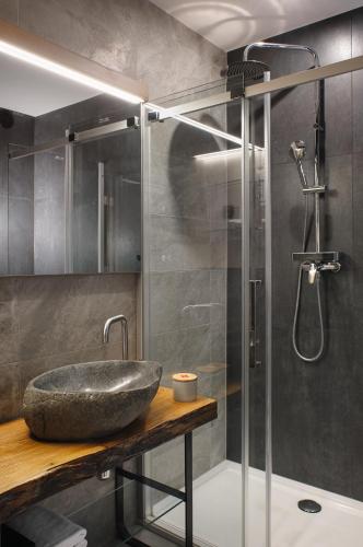 a bathroom with a stone sink and a shower at CITYMAP HOTEL APARTMENTS Maribor-Free parking! in Maribor