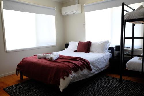 a bedroom with a bed with a red blanket at Mirra Minga in Kevington