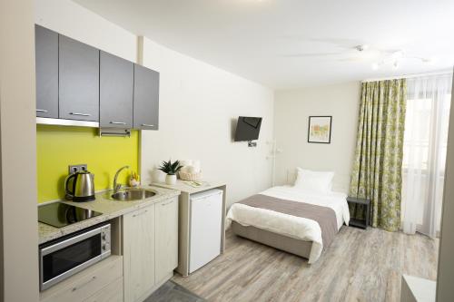 a kitchen with a sink and a bed in a room at Arima city in Shumen