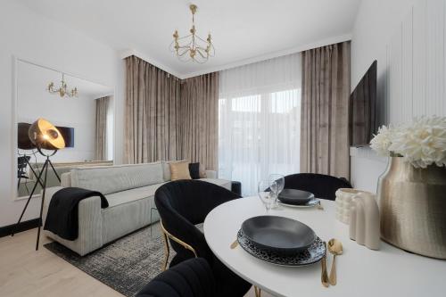 een woonkamer met een bank en een tafel met stoelen bij New Studio Nyska with FREE GARAGE Wrocław by Renters in Wrocław