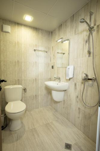 a bathroom with a toilet and a sink and a shower at Arima city in Shumen