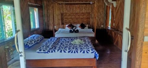a bedroom with two beds with blue and white sheets at Koh Jum Freeda Resort in Ko Jum