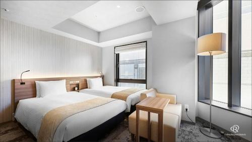 a hotel room with two beds and a window at Daiwa Roynet Hotel Shimbashi in Tokyo