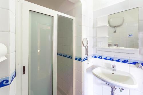 a white bathroom with a sink and a mirror at Hotel Ferdinando Beach & Thermal Spa in Ischia