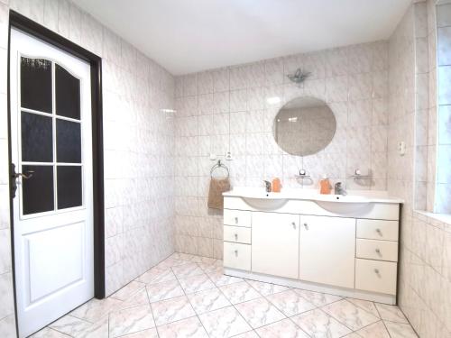 La salle de bains est pourvue d'un lavabo blanc et d'un miroir. dans l'établissement Elements Apartments, à Ostrov