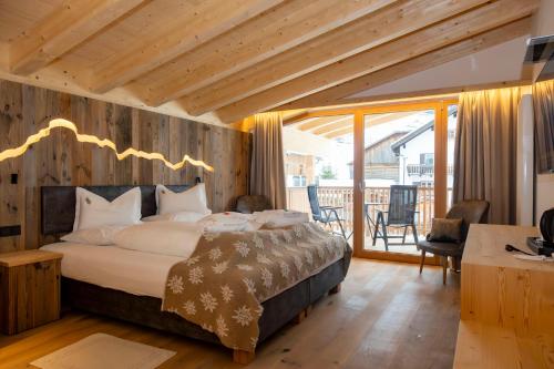 a bedroom with a large bed and a balcony at Hotel Rezia in La Villa