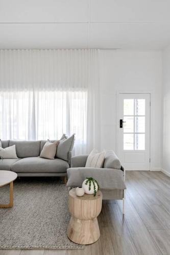 a living room with a couch and a table at Casa Wilde in the Hunter in Cessnock