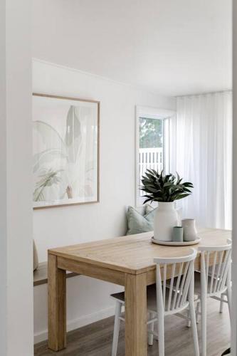 a dining room table with a potted plant on it at Casa Wilde in the Hunter in Cessnock