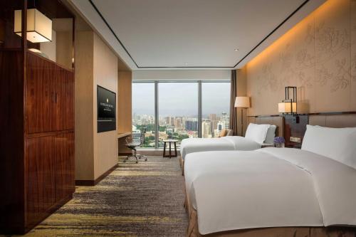a hotel room with two beds and a television at InterContinental Fuzhou in Fuzhou