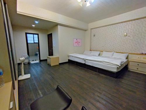 a large room with a bed and a chair in it at 1986 Travel Hall in Tainan