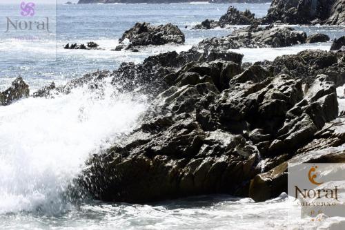 a wave crashing on the rocks in the ocean at Nuevo Norat Sanxenxo in Sanxenxo